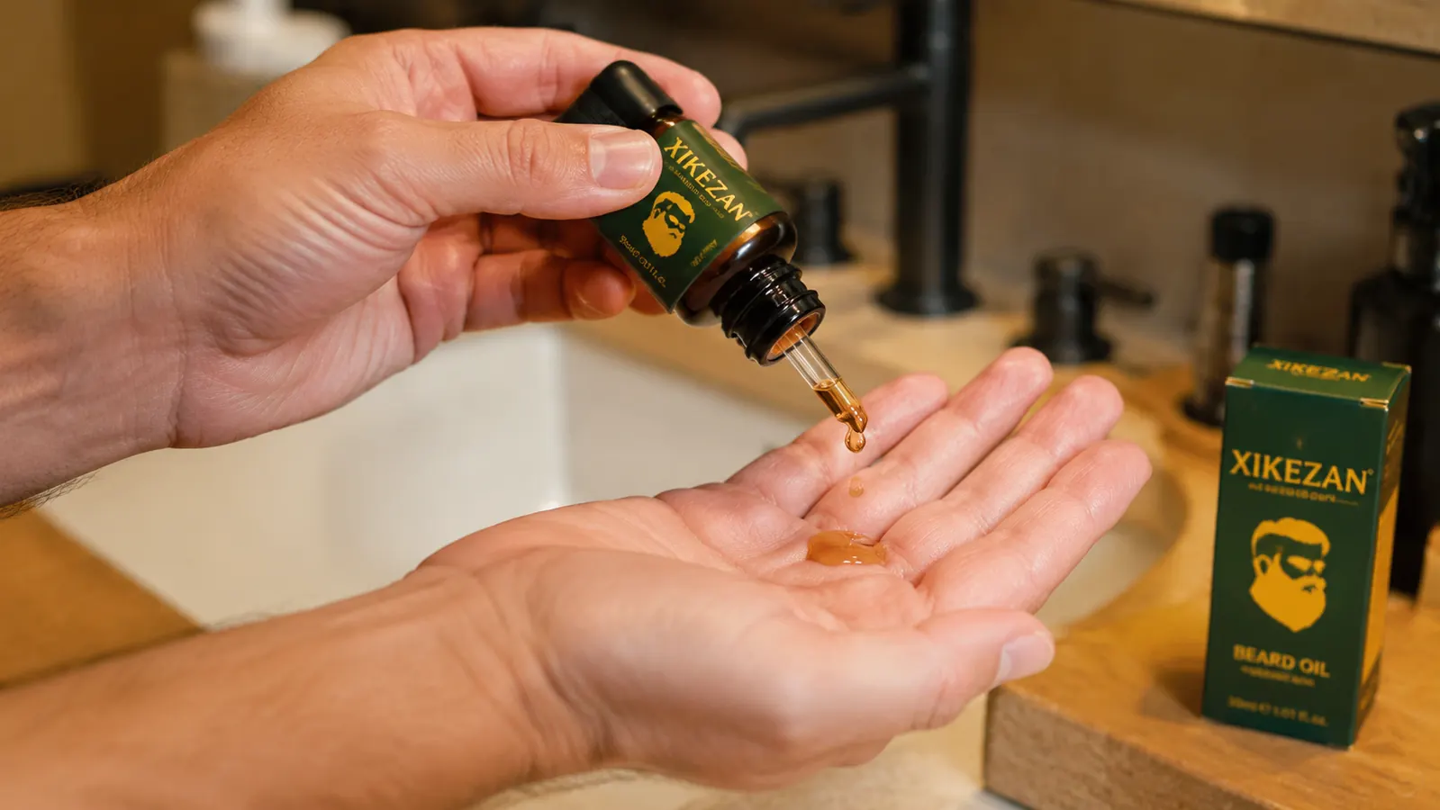 Hands dispensing a few drops of beard oil from a small amber bottle into the palm
