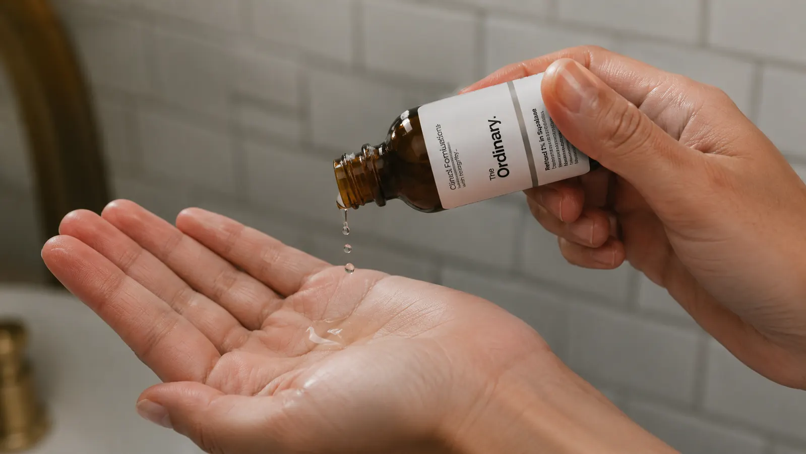 Close-up of The Ordinary Retinol serum dropper being held over a palm showing a few drops